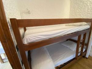 a wooden bunk bed with white sheets on it at Appartement Le Grand-Bornand, 1 pièce, 4 personnes - FR-1-241-141 in Le Grand-Bornand