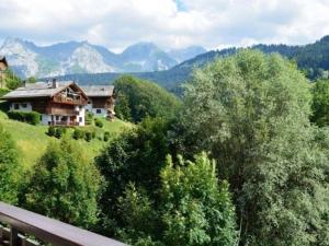 a house on a hill with mountains in the background at Appartement Le Grand-Bornand, 2 pièces, 5 personnes - FR-1-241-142 in Le Grand-Bornand