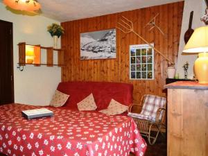 a bedroom with a red bed with a table and a window at Appartement Le Grand-Bornand, 2 pièces, 6 personnes - FR-1-241-152 in Le Grand-Bornand