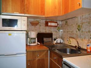 a kitchen with a white refrigerator and a sink at Appartement Le Grand-Bornand, 2 pièces, 6 personnes - FR-1-241-152 in Le Grand-Bornand