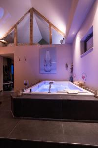 bañera grande en una habitación con techo en Le Cottage Suite avec Spa Privatif, 