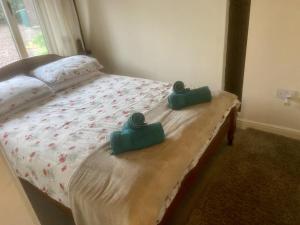a bed with two green towels on it at Beautiful 1-Bed House in Gloucestershire in Westbury on Severn