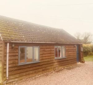 a log cabin with two windows and a roof at Beautiful 1-Bed House in Gloucestershire in Westbury on Severn