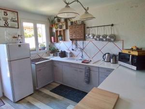 a kitchen with white cabinets and a white refrigerator at Maison à 300m plage a Valras Plage 2 chambres in Sérignan