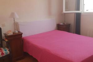 a bedroom with a pink bed and a window at Maison à 300m plage a Valras Plage 2 chambres in Sérignan