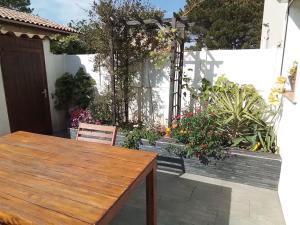 a patio with a wooden table and some plants at Maison à 300m plage a Valras Plage 2 chambres in Sérignan