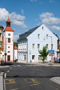 a white building with a clock tower next to a street at Marcebila Abertamy in Abertamy