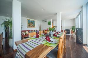 uma sala de jantar com uma mesa de madeira com pratos e pratos em Suzuki Villa Ketewel Beachfront em Ketewel