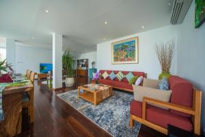 a living room with a red couch and a table at Suzuki Villa Ketewel Beachfront in Ketewel