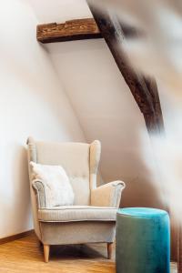 salon z krzesłem i niebieską otomaną w obiekcie JAMA - Großes Design Apartment, Innenstadt, WLAN, Familie&Gruppen w mieście Coburg