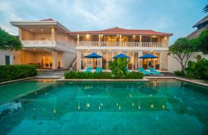 a villa with a swimming pool in front of a house at Suzuki Villa Ketewel Beachfront in Ketewel