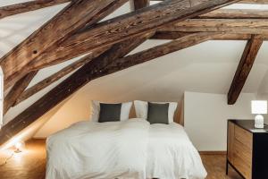 sypialnia z białym łóżkiem i drewnianym sufitem w obiekcie JAMA - Großes Design Apartment, Innenstadt, WLAN, Familie&Gruppen w mieście Coburg