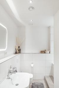 biała łazienka z umywalką i toaletą w obiekcie JAMA - Großes Design Apartment, Innenstadt, WLAN, Familie&Gruppen w mieście Coburg