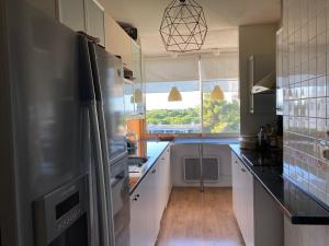 eine Küche mit einem Kühlschrank aus Edelstahl und einem Fenster in der Unterkunft Appartement familial 92m2 avec terrasse vue mer in La Grande-Motte
