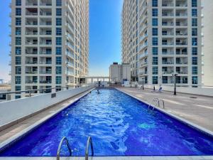 ein Pool auf dem Dach eines Gebäudes mit hohen Gebäuden in der Unterkunft The Smart Concierge - DEC Tower in Dubai