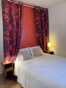 Schlafzimmer mit einem Bett mit roten Wänden und Vorhängen in der Unterkunft Appartement familial 92m2 avec terrasse vue mer in La Grande-Motte