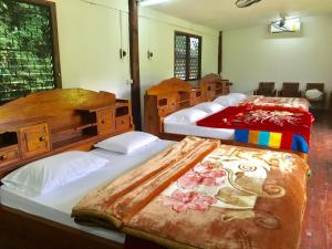 - deux lits dans une chambre avec deux couvre-lits dans l'établissement The Creek Garden Resort Huainamrin ห้วยนำ้ริน, à Mae Hong Son