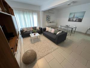 Amazing 2-bedroom apartment with pool!! في ليماسول: غرفة معيشة مع أريكة وطاولة
