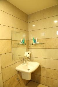 a bathroom with a sink and a mirror at Hotel Reva Regency in Bhopal