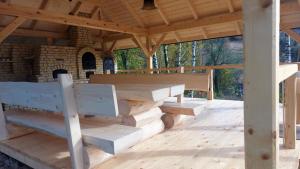 - un pavillon en bois avec une table et des bancs sur une terrasse dans l'établissement Osada Sudecka, à Lądek-Zdrój