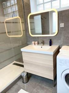 a bathroom with a sink and a mirror and a washing machine at F2 calme, Château, Grand Parquet, Fôret in Avon