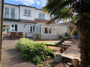een huis met een patio met een hangmat in de tuin bij 3-Bedroom Family Home. Just 5 Mins From The Beach! in Kent