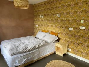 a bedroom with a bed and a wall at Steinholt, charming & just renovated apartment ! in Seyðisfjörður