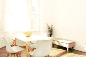a dining room with a white table and chairs at Suite 4 - Comfy Bedroom near MCR Centre in Manchester