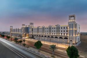 ein großes weißes Gebäude mit einer Straße davor in der Unterkunft Braira Al Ahsa in Al-Hasa