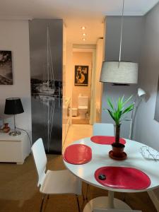 una sala da pranzo con tavolo e sedie rossi e bianchi di Apartamento Puerto Deportivo Marina de Santander a Santander
