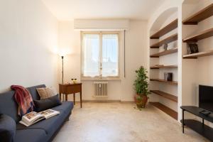 a living room with a blue couch and a window at Beccaria - Flo Apartments in Florence