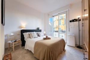 a white bedroom with a large bed and a window at Beccaria - Flo Apartments in Florence