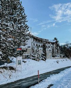 a building in the snow with a sign in front of it at Rothenfels Hotel & Panorama Restaurant in Immenstadt im Allgäu