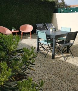 d'une terrasse avec des chaises et une table et des chaises noires. dans l'établissement Villa Santoline, Saint-Denis-d'Oléron, à Saint-Denis-dʼOléron
