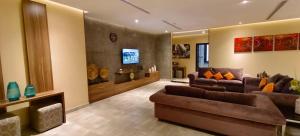 a living room with two couches and a tv at Q Suites Jeddah by EWA - Managed by HMH in Jeddah