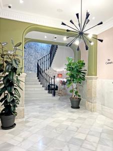 a hallway with a staircase with potted plants at Soho Boutique Turia in Valencia