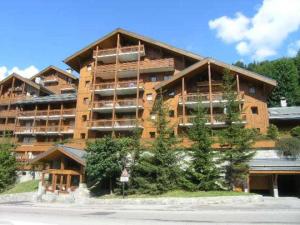 a large apartment building with a large at Appartement pour 6, centre Méribel, proche commerces et pistes, piscine l'été - FR-1-180-303 in Méribel