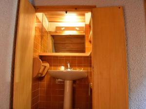 małą łazienkę z umywalką i lustrem. w obiekcie Appartement Méribel, 1 pièce, 5 personnes - FR-1-180-304 w Méribel
