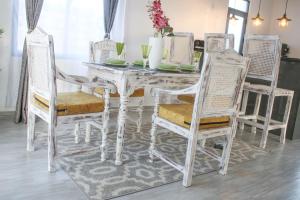 a white dining room table with two chairs and a white table at Shany’s Villa 3bdrm with private swimming pool in Mombasa
