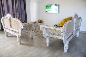 two white chairs sitting next to each other in a room at Shany’s Villa 3bdrm with private swimming pool in Mombasa