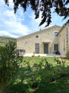 una casa de piedra en medio de un campo en Mas de Veyras - Gîtes 5 étoiles en Ardèche en Lachapelle-sous-Aubenas