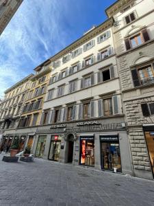 a large building on a city street with stores at Hotel Maxim Axial in Florence
