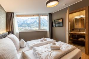a hotel room with two beds and a window at Zugspitz Residence Ehrwald in Ehrwald