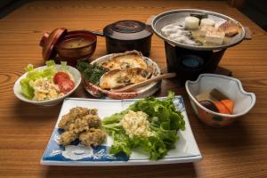 a table with a plate of food on a table at Hotel Tsustujisou in Kitami