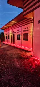 a building with pink lights on the side of it at Touch the Wind in Chaiyaphum
