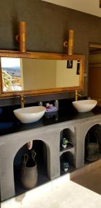 a bathroom counter with two sinks and a mirror at Hotel Kasbah Ennakhile - Authentic Stay in Nkob in Nkob