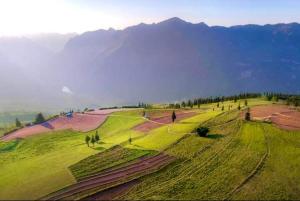 a group of people on a field with mountains in the background at Bình Minh Homestay in Nam Giang