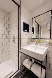 La salle de bains blanche est pourvue d'un lavabo et d'un miroir. dans l'établissement The Wesley Camden Town, à Londres