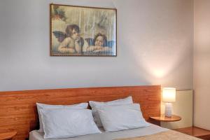 un cuadro sobre una cama con almohadas blancas en Villa Egola, en San Miniato