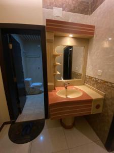 a bathroom with a sink and a mirror and a toilet at Golden New Al Dar - جولدن نيو الدار in Jazan